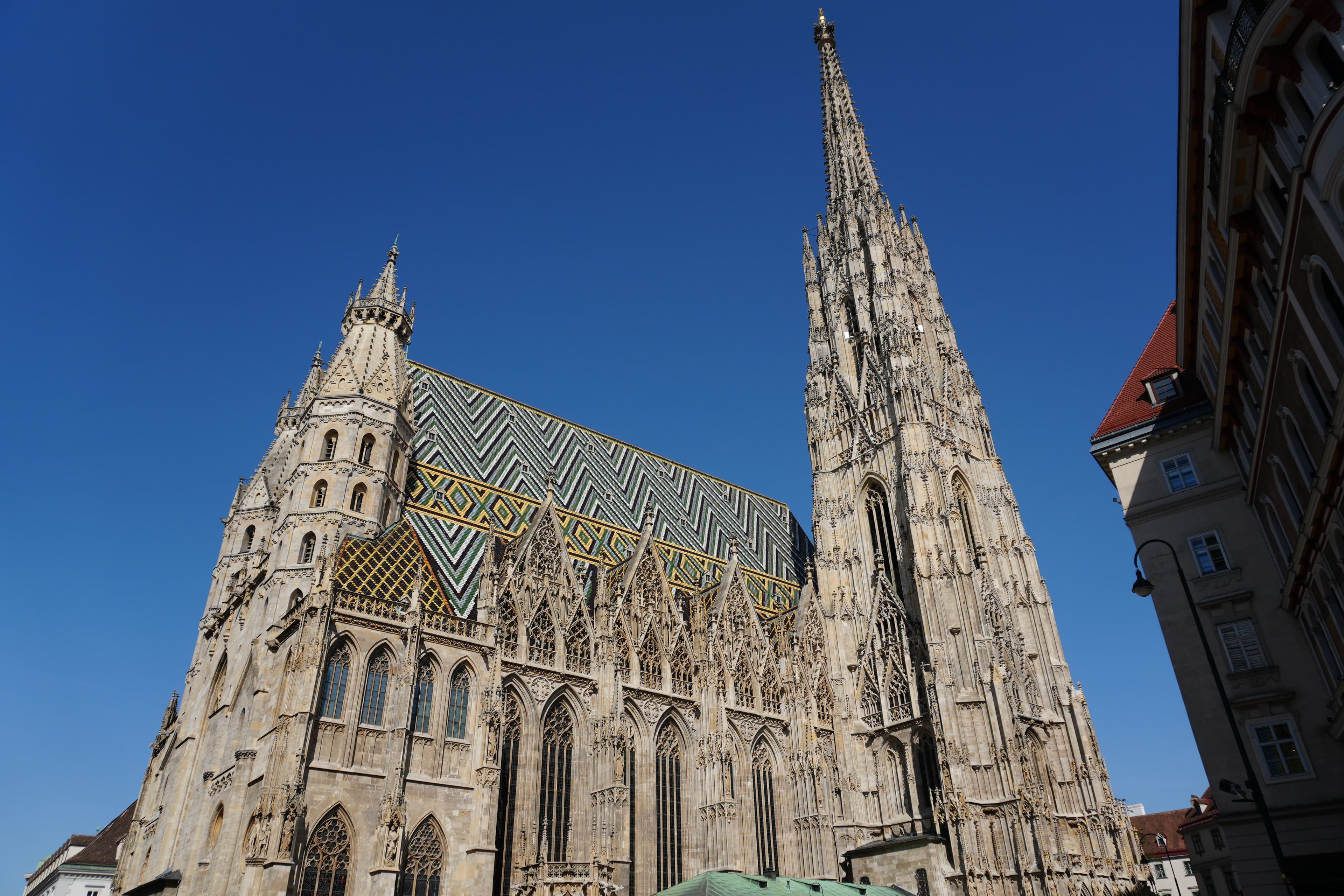 A Stephansdom gótikus tornyai és jellegzetes mintás cseréptetője kék ég alatt