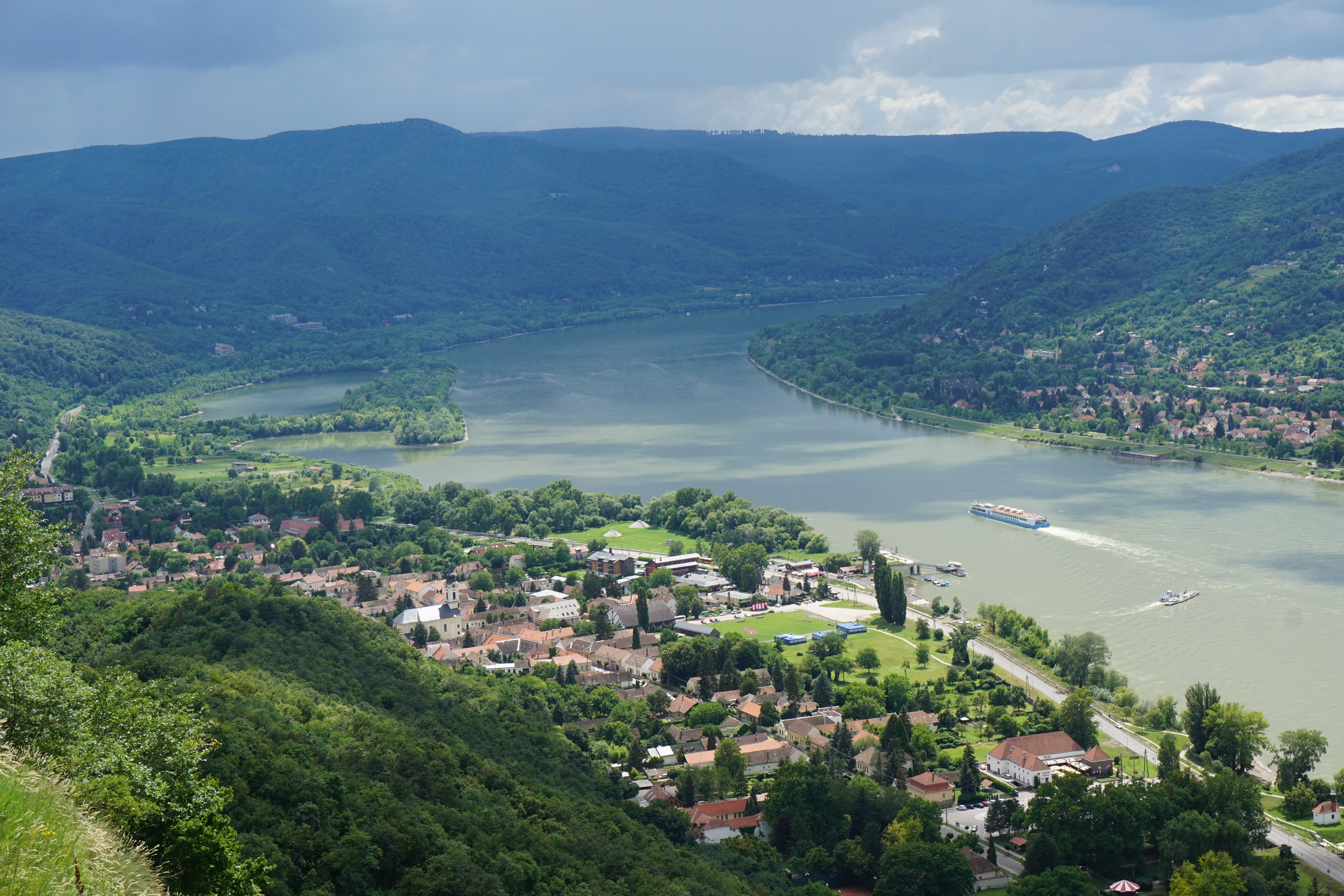 Panorámakilátás a Dunakanyarra Visegrádról, hajóval a folyón és erdős dombokkal körülvéve